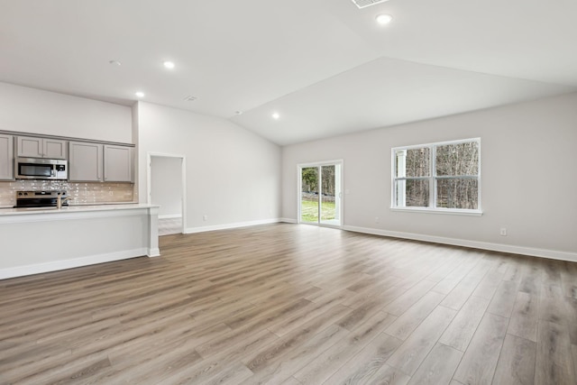 unfurnished living room featuring light hardwood / wood-style flooring and vaulted ceiling