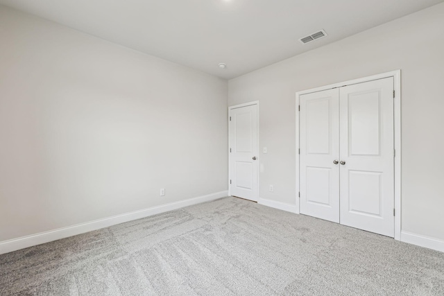 unfurnished bedroom featuring carpet flooring and a closet