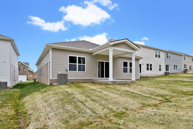 rear view of property featuring central AC and a yard