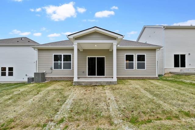 rear view of property with a lawn, cooling unit, and a patio area