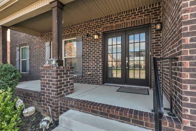 view of exterior entry with french doors and a porch