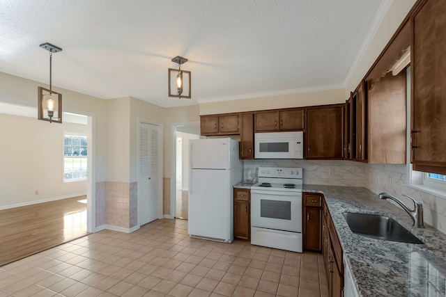 kitchen featuring sink, hanging light fixtures, white appliances, light tile patterned floors, and ornamental molding