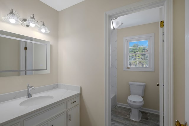 bathroom with hardwood / wood-style floors, vanity, a bathtub, and toilet