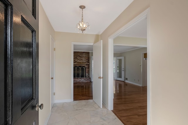 hall with ornamental molding, a notable chandelier, and light wood-type flooring