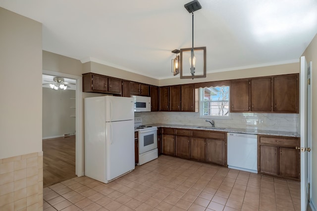 kitchen with crown molding, sink, hanging light fixtures, and white appliances