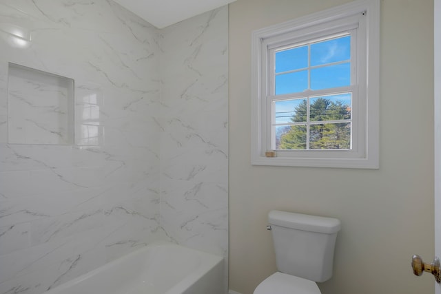 bathroom featuring tiled shower / bath and toilet