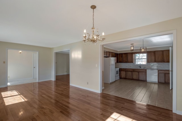 kitchen with decorative backsplash, decorative light fixtures, white appliances, and dark hardwood / wood-style floors