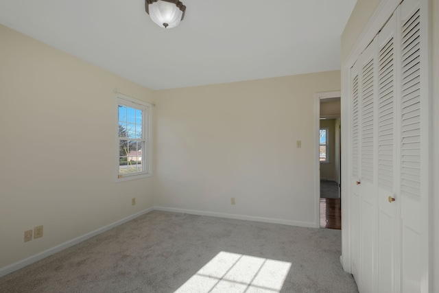 unfurnished bedroom featuring light carpet and a closet