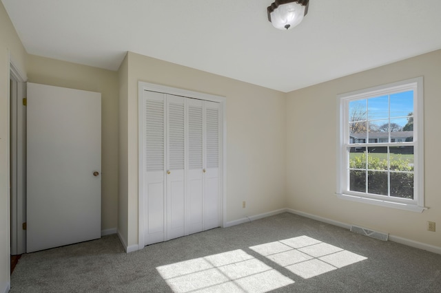 unfurnished bedroom featuring light colored carpet and a closet