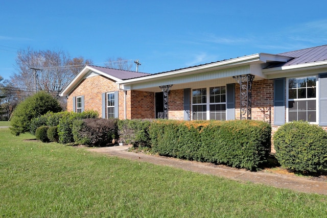 view of side of home featuring a porch and a lawn