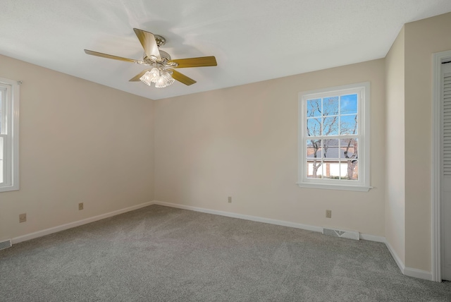 carpeted spare room with ceiling fan