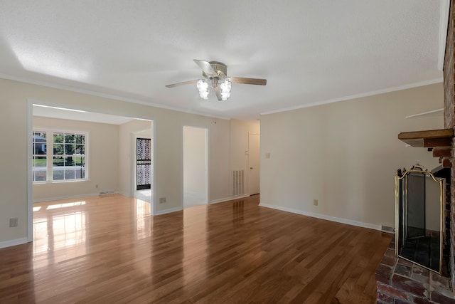 unfurnished living room featuring ceiling fan, dark hardwood / wood-style flooring, a textured ceiling, and ornamental molding