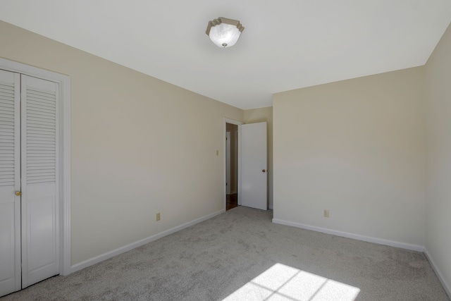 unfurnished bedroom with light carpet and a closet