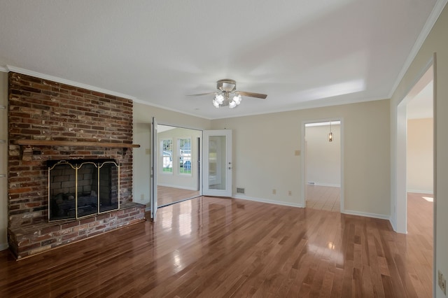 unfurnished living room featuring ceiling fan, a fireplace, ornamental molding, and hardwood / wood-style flooring