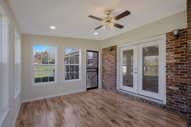 unfurnished sunroom with ceiling fan and french doors