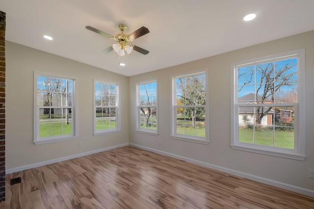 empty room with lofted ceiling, ceiling fan, and light wood-type flooring