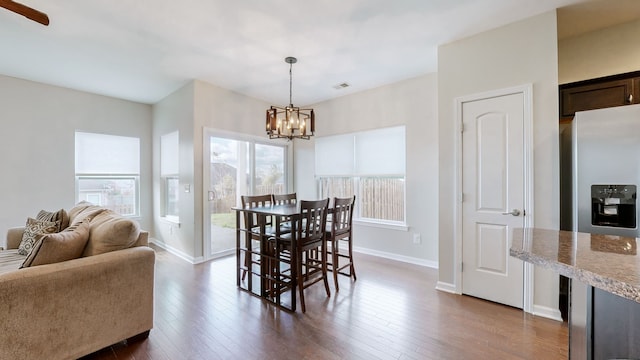 dining area featuring a chandelier and dark wood-type flooring