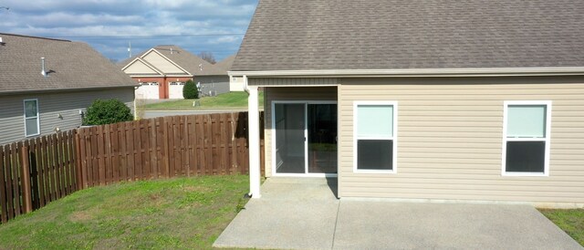 entrance to property featuring a lawn and a patio area