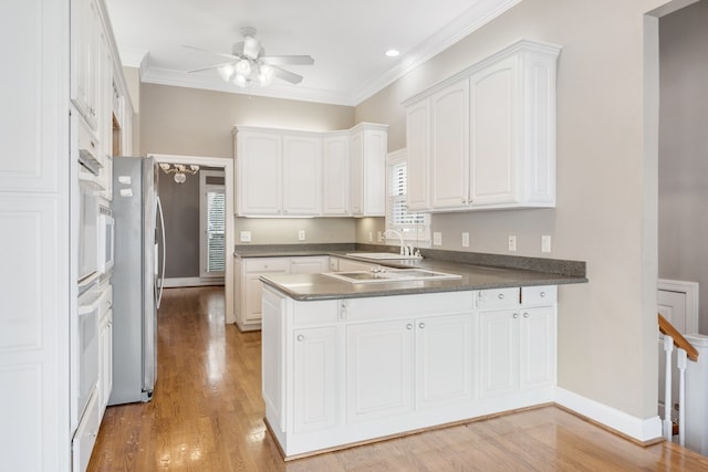 kitchen featuring white cabinetry, plenty of natural light, and ornamental molding