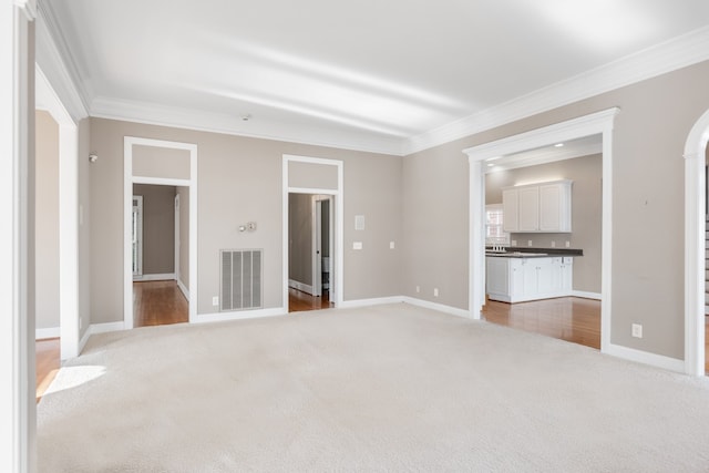 unfurnished bedroom featuring connected bathroom, carpet, and ornamental molding