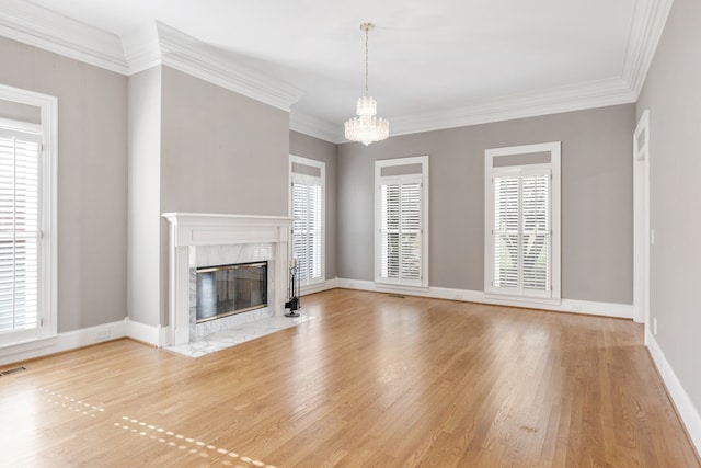 unfurnished living room featuring a fireplace, light hardwood / wood-style flooring, a healthy amount of sunlight, and ornamental molding