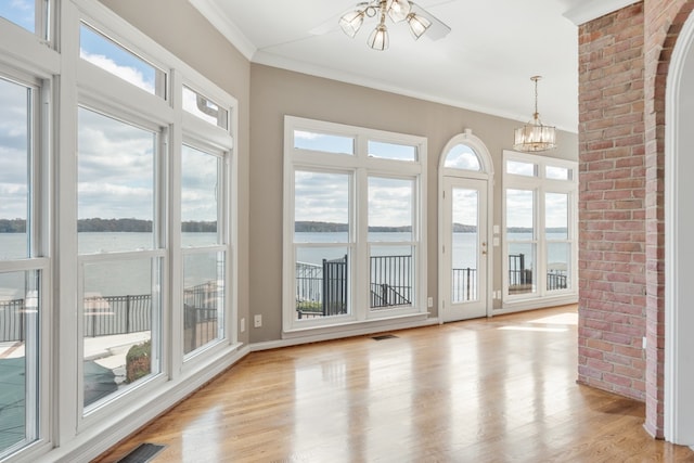 interior space with a water view, a wealth of natural light, and light hardwood / wood-style flooring