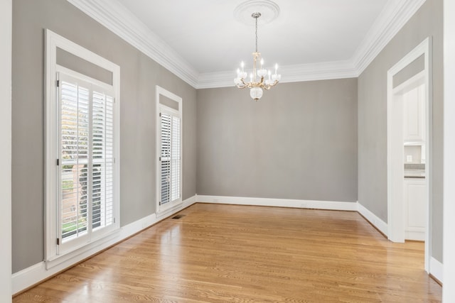 unfurnished room with a healthy amount of sunlight, light hardwood / wood-style floors, and a chandelier