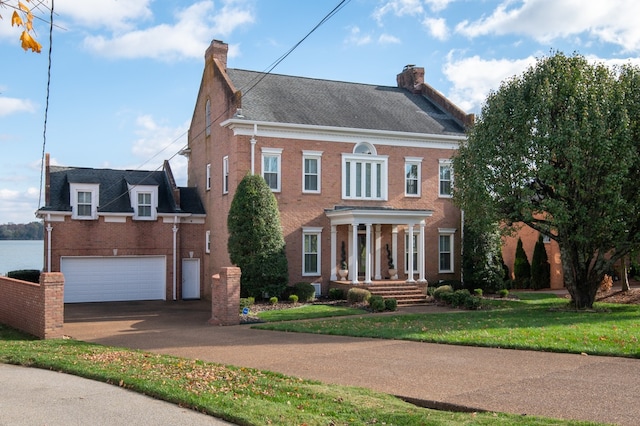 colonial home featuring a garage and a front lawn