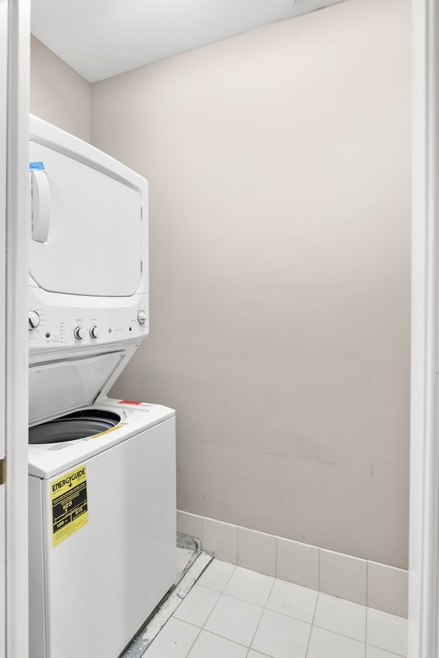 clothes washing area featuring light tile patterned floors and stacked washer / drying machine