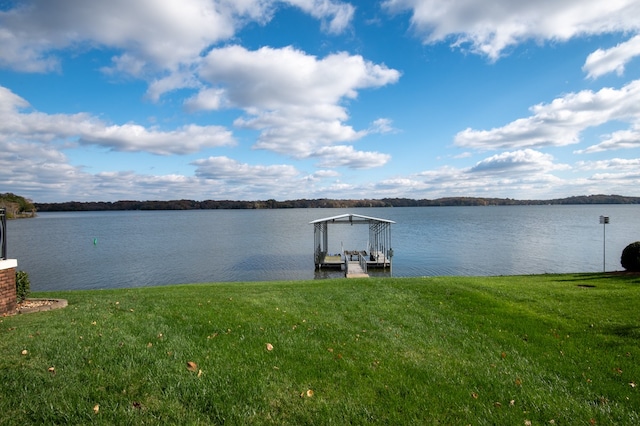 view of dock featuring a lawn and a water view