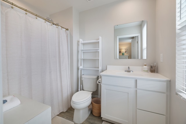 bathroom featuring vanity, a healthy amount of sunlight, and toilet