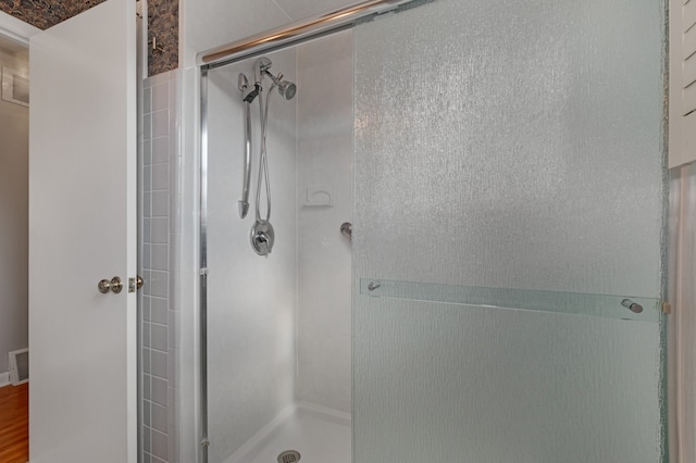 bathroom featuring wood-type flooring and a shower with door