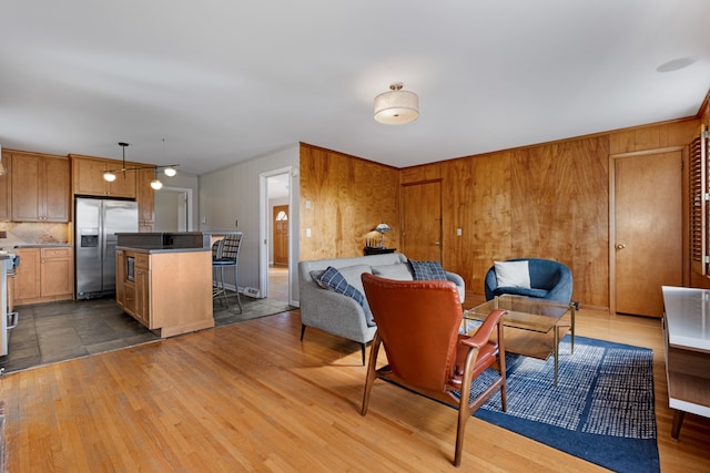 living room with wood walls and light hardwood / wood-style flooring