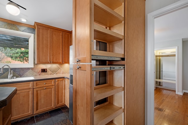 kitchen featuring decorative backsplash, dark hardwood / wood-style flooring, and sink