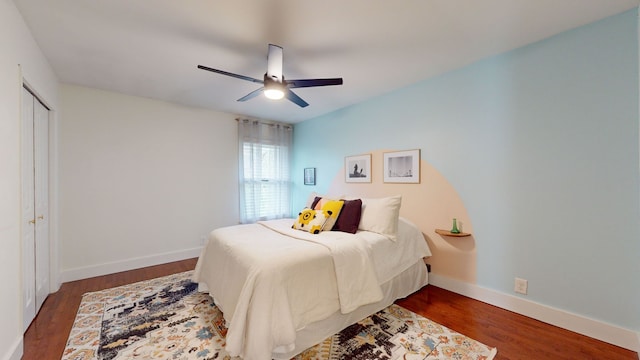 bedroom featuring dark wood-type flooring, ceiling fan, and a closet