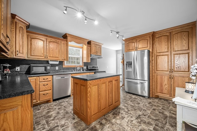 kitchen with backsplash, appliances with stainless steel finishes, and a center island