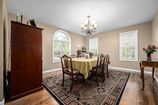 dining area with an inviting chandelier and hardwood / wood-style flooring