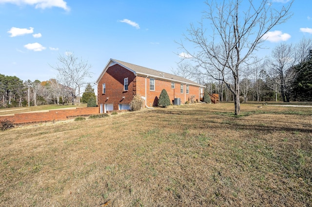 view of home's exterior featuring a garage, central air condition unit, and a yard