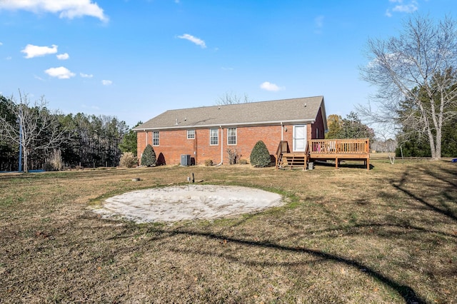 rear view of house with a lawn, cooling unit, and a wooden deck