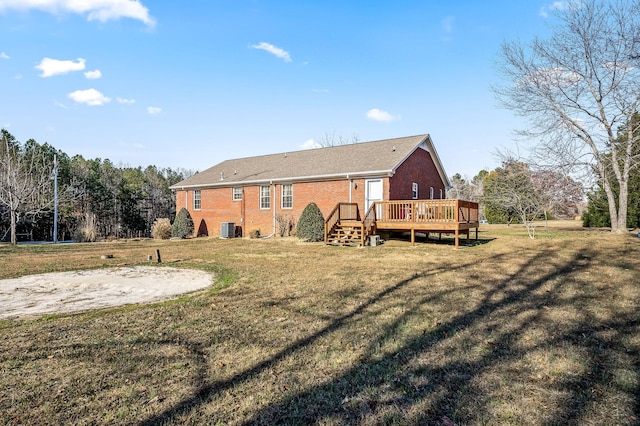 back of property with a deck, central air condition unit, and a yard