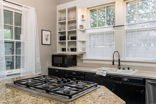 kitchen featuring light stone counters, sink, and stainless steel appliances