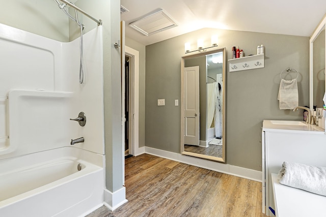 bathroom with hardwood / wood-style floors, vanity, lofted ceiling, and tub / shower combination