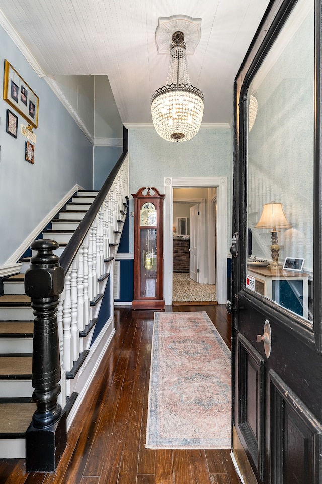 entrance foyer featuring a chandelier, crown molding, and dark wood-type flooring