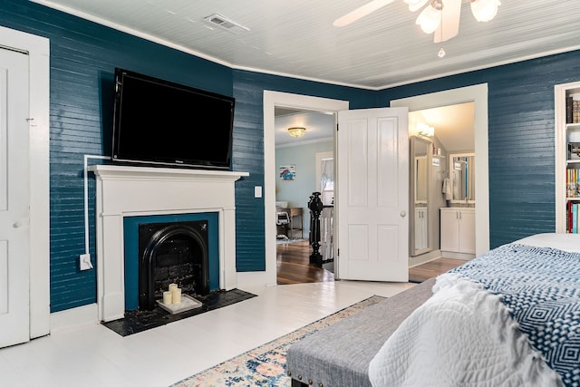 bedroom featuring hardwood / wood-style flooring, ceiling fan, ornamental molding, and ensuite bathroom