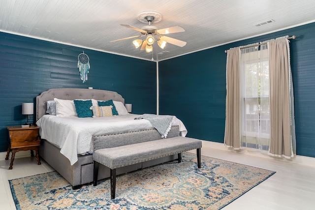 bedroom with light hardwood / wood-style flooring, ceiling fan, and ornamental molding