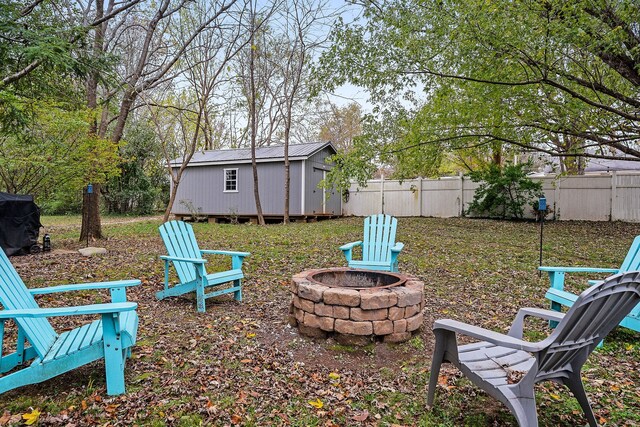 view of yard featuring a storage unit and an outdoor fire pit