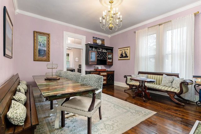 dining room featuring dark hardwood / wood-style flooring, ornamental molding, and an inviting chandelier