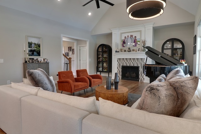 living room with hardwood / wood-style flooring, ceiling fan, and high vaulted ceiling