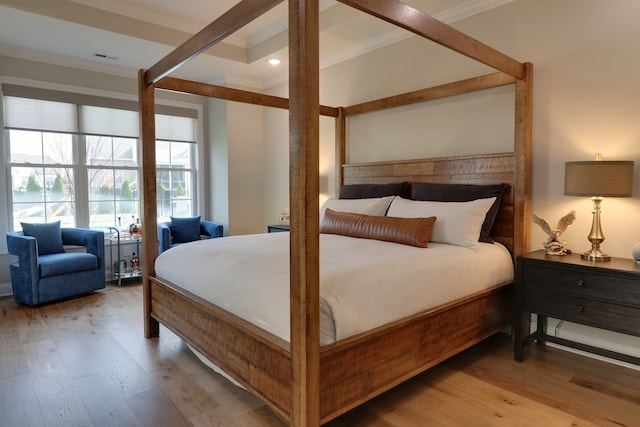 bedroom featuring ornamental molding and light hardwood / wood-style floors