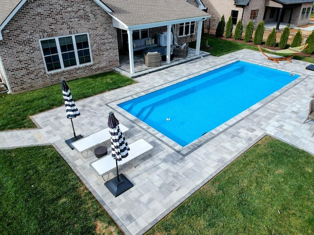 view of pool featuring a patio, an outdoor hangout area, and a lawn